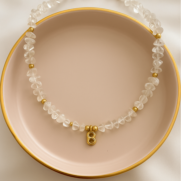 Load image into Gallery viewer, Necklace with clear beads and gold accents on a pink plate